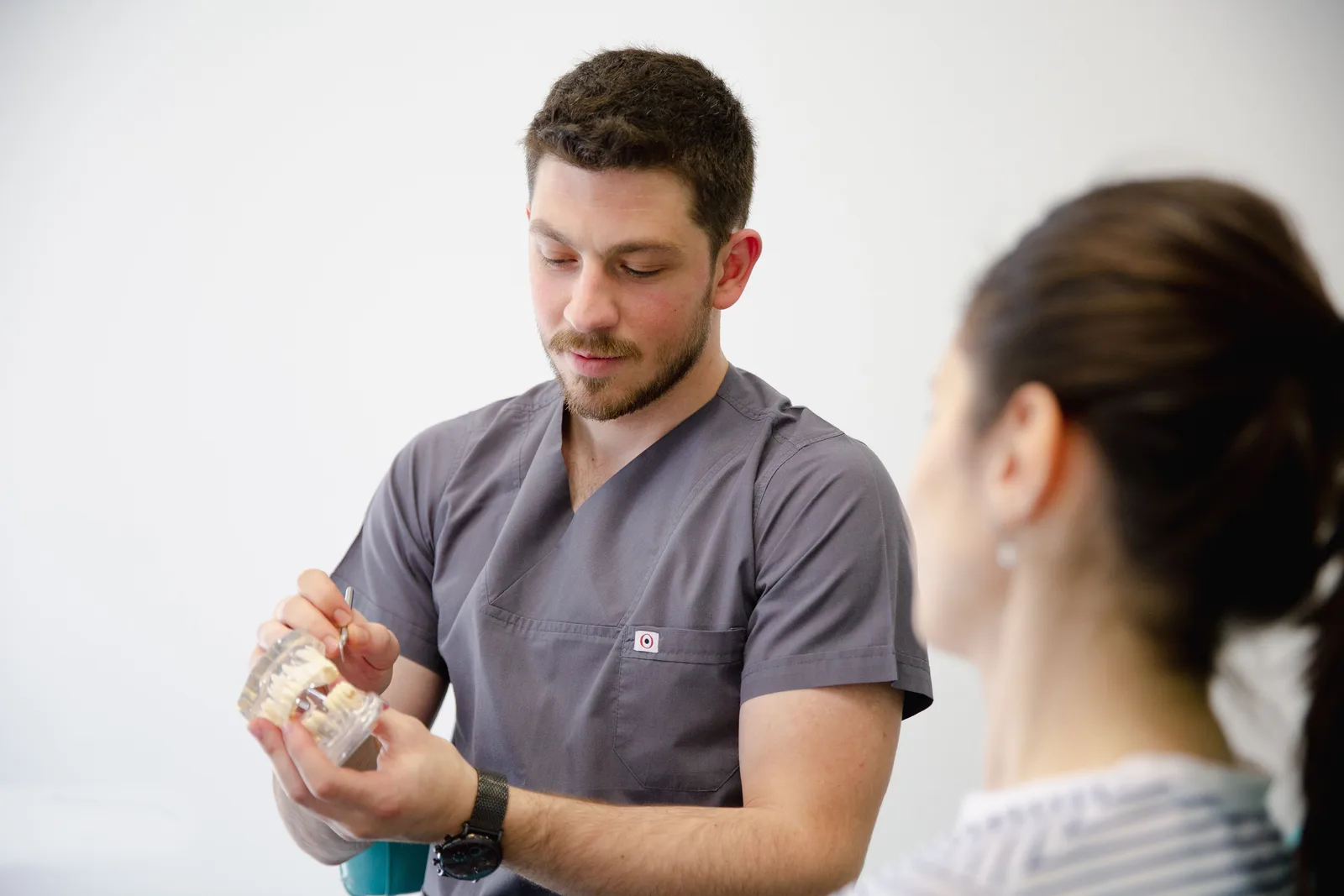 Dentist showing an implant model during a consultation, referred to in the Single Tooth Implant section for Virginia Beach