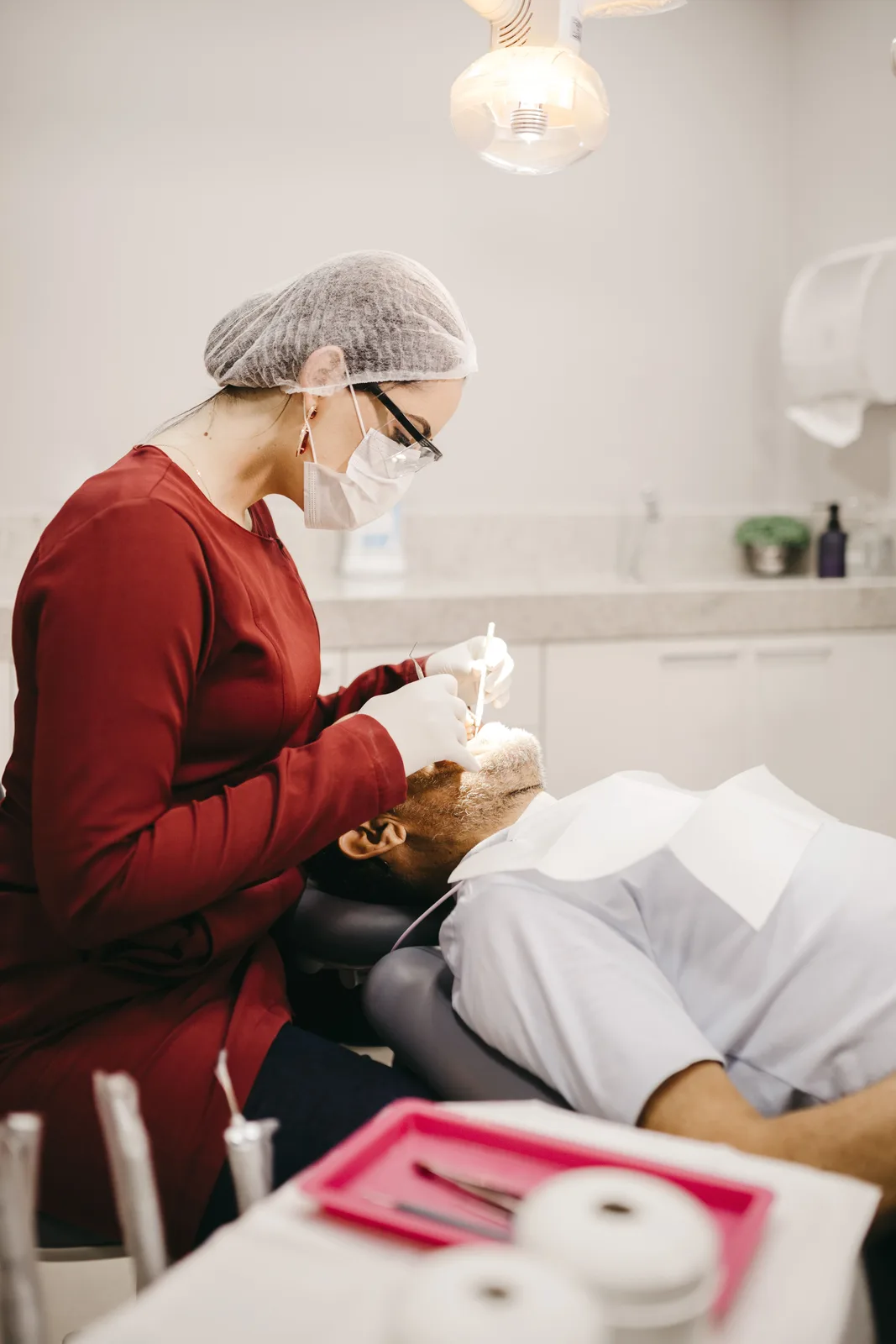 Dentist working under the operatory light, referred to in the Implant Procedures section for Virginia Beach